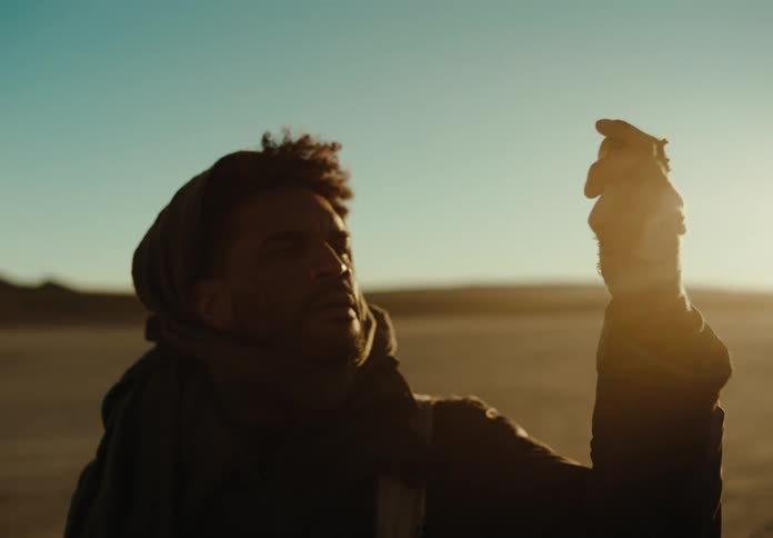 Man holds compass up to the sky and brings it back down again