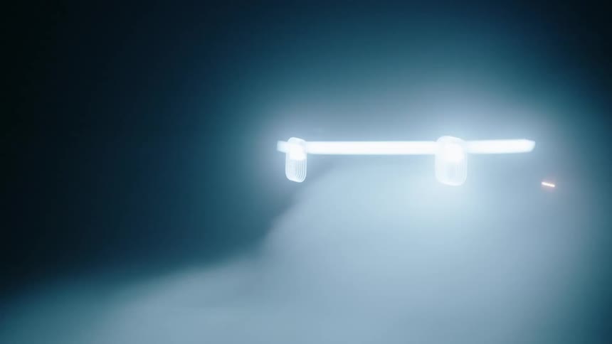 A pick up truck speeds across the desert at night the only light source being its headlights