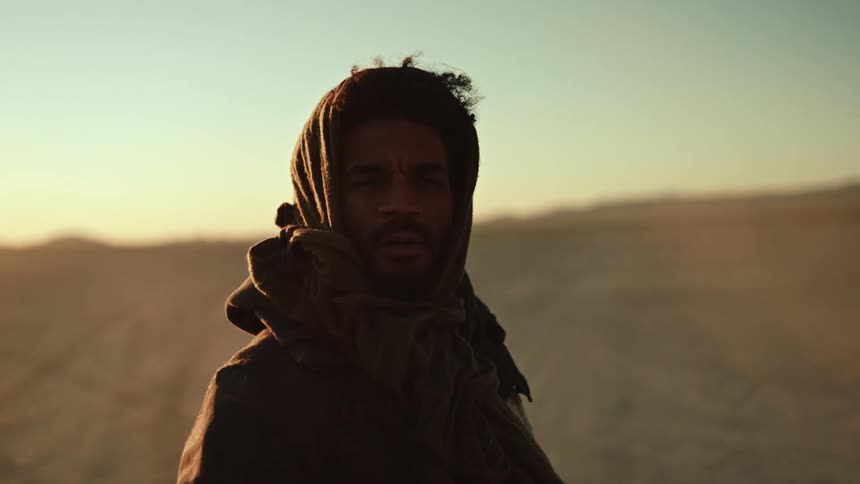 A man stands in the middle of the desert