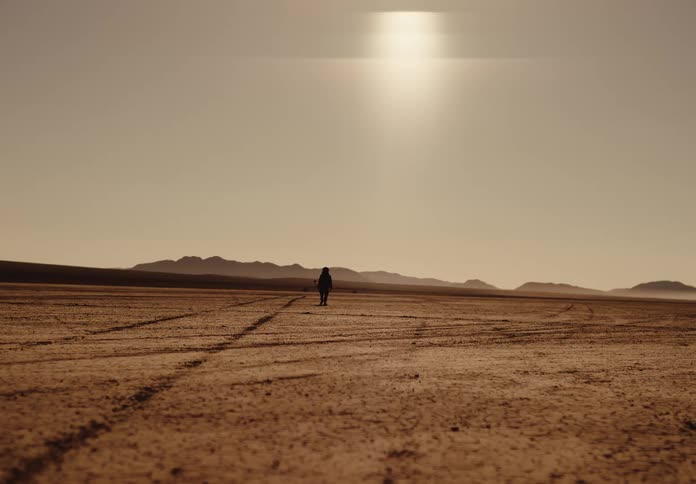 A person is walking through the desert