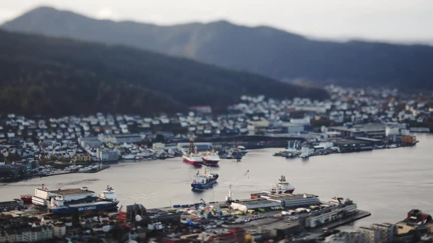 An aerial view of a busy dock with a cargo ship sailing off
