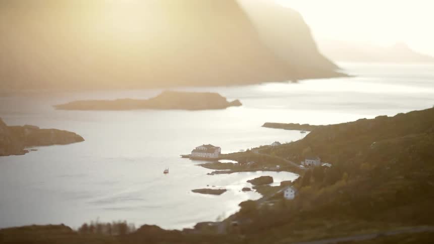 A house on the edge of a huge lake that connects to the sea in a region with several islands in the sea and strong sunlight from the sky