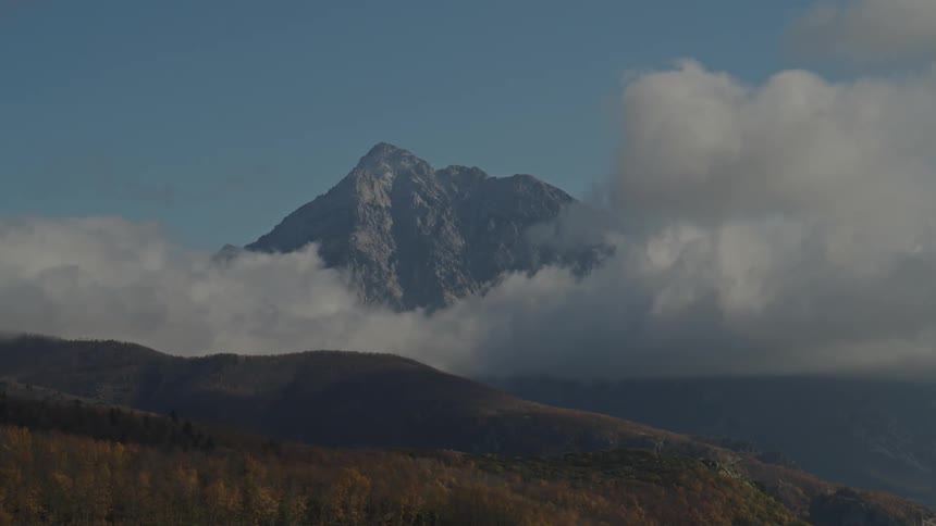 A mountain range surrounded by large clouds