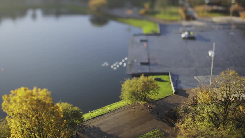 Top view of people walking by a lake in timelapse