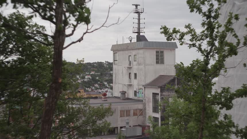 A large antenna is at the top of the building