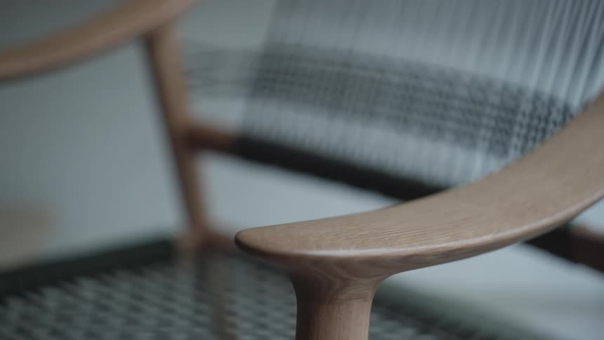 Smooth wooden chair arm curves upward slowly