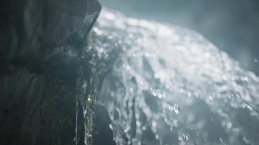Water of a flowing river falling from a rock in slow motion