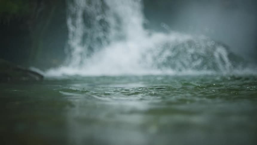 A massive waterfall crashes into the river below