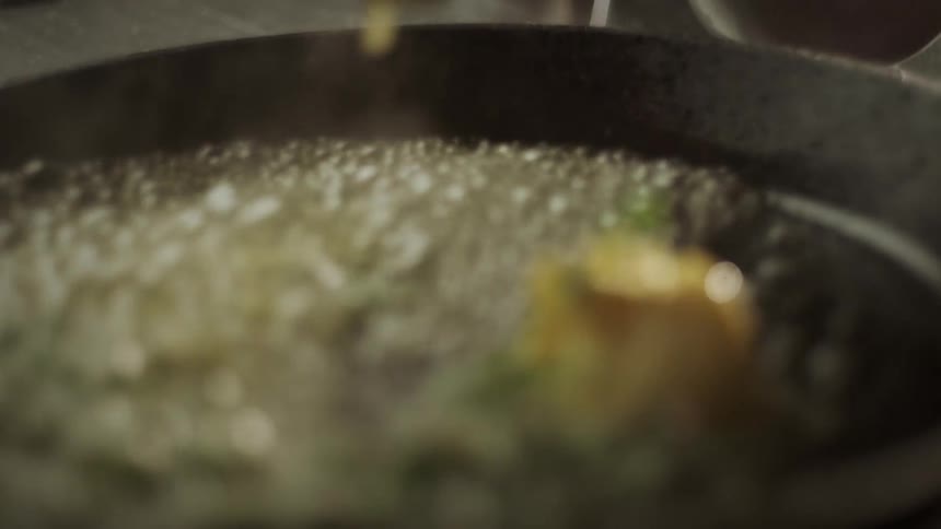 Closeup of butter with the help of a spoon being melted in a frying pan