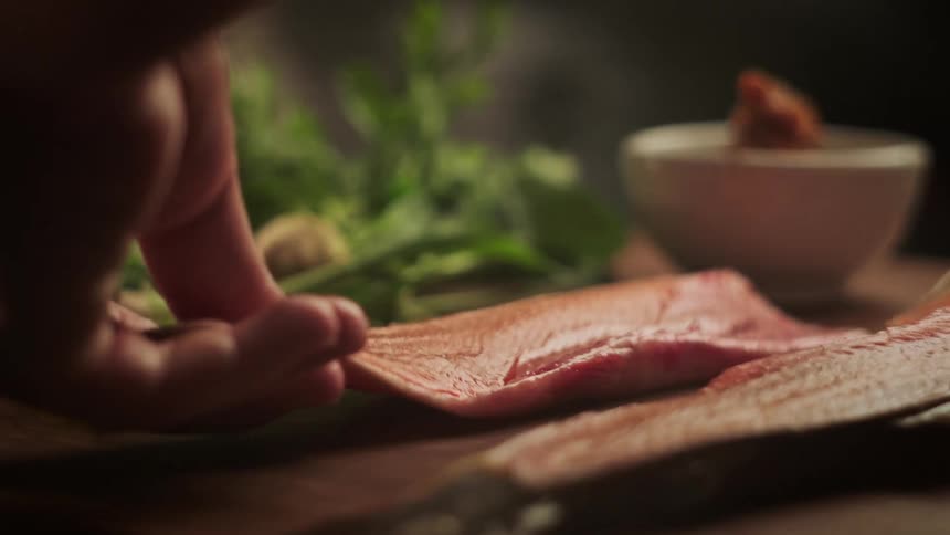 A man pulls a fish apart