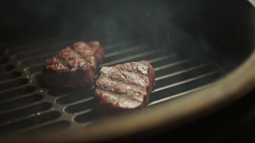 Two steaks on a hot grill
