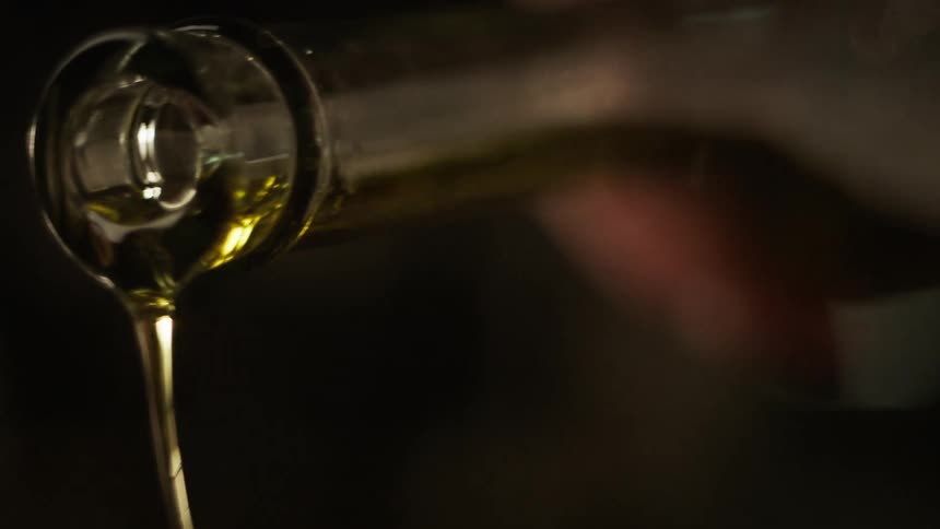 A shot of olive oil being poured in slow motion