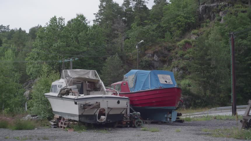 Two boats sitting outdoors on trailers