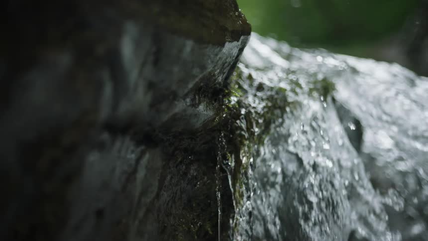 A water stream flowing and falling over a rock