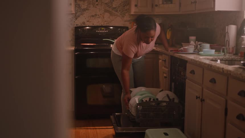 A woman is emptying the dish washer