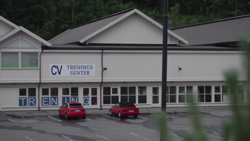 Two red cars parked in front of the training center