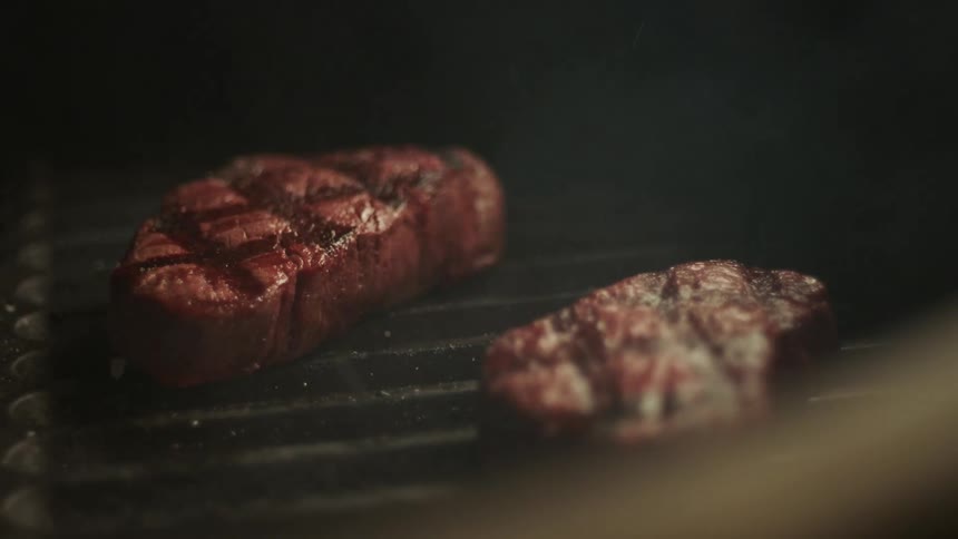 Beef steaks grilling on a bbq