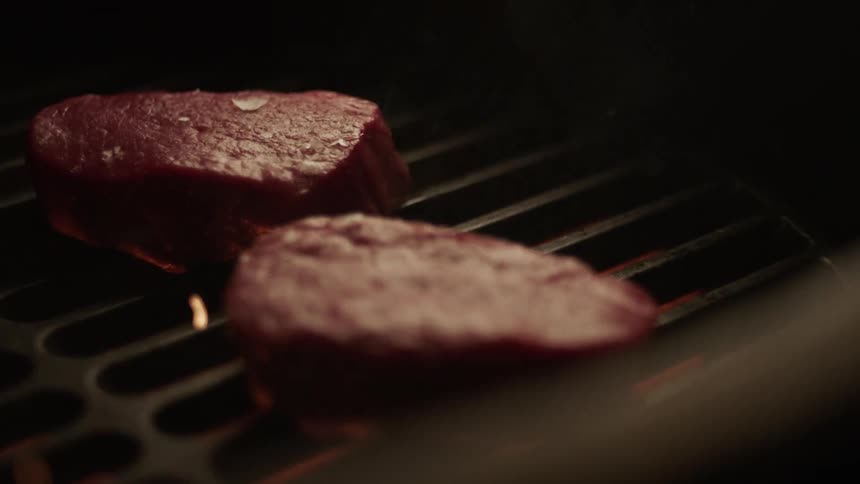 Two cuts of grilled meat being roasted