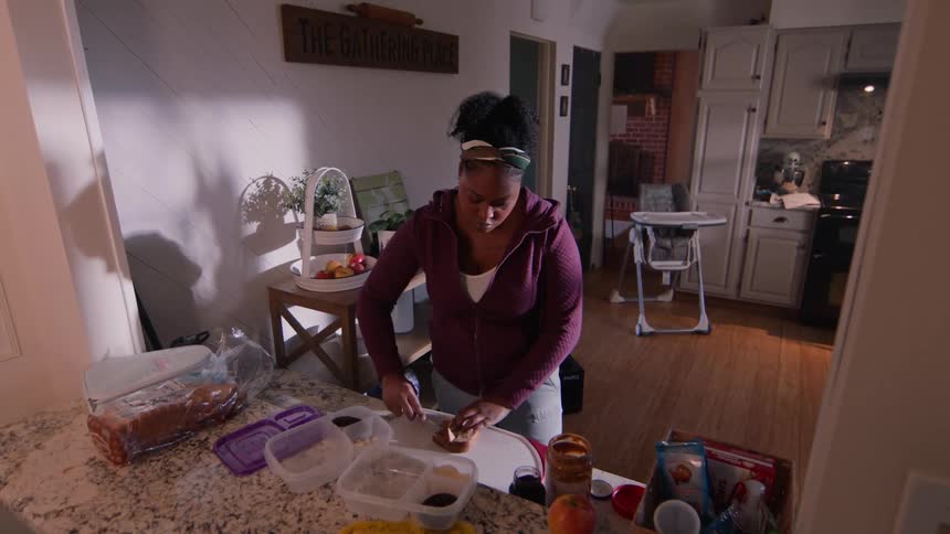 Woman in the kitchen preparing and eating bread