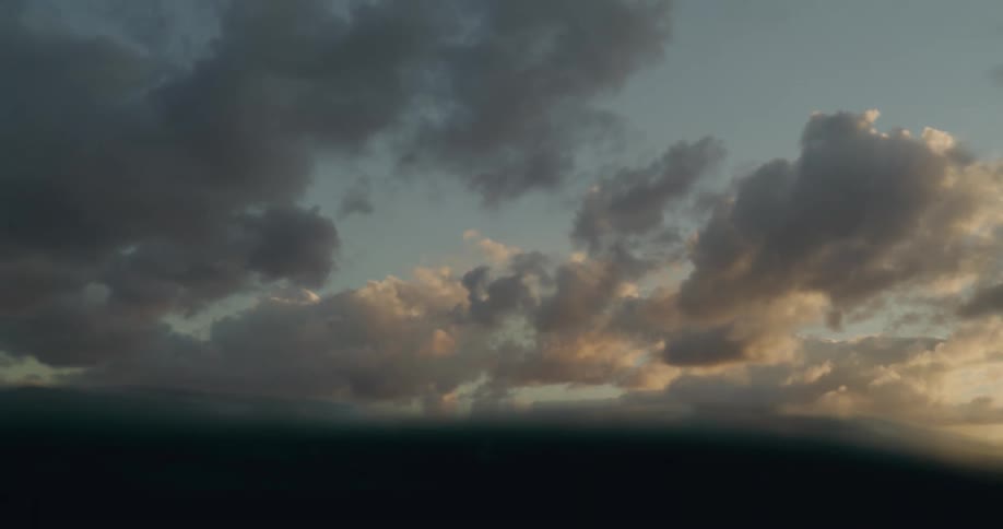 Waves roll across ocean under a cloudy sky