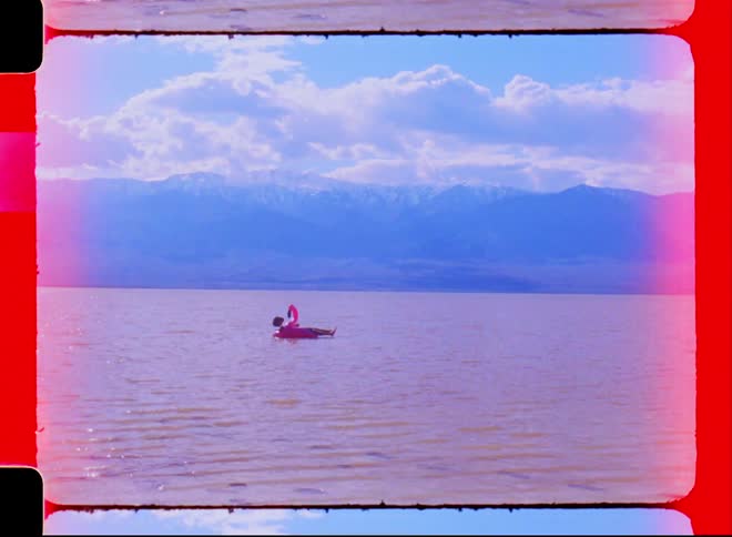 A person uses a flotation device to float on the ocean