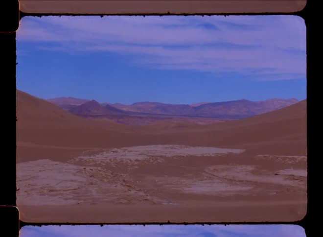 Panorama of a natural desert site with mountains and canyons on the horizon on a blue sky day with clouds
