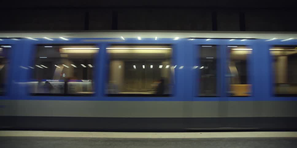 Passengers ride on subway car passing through station