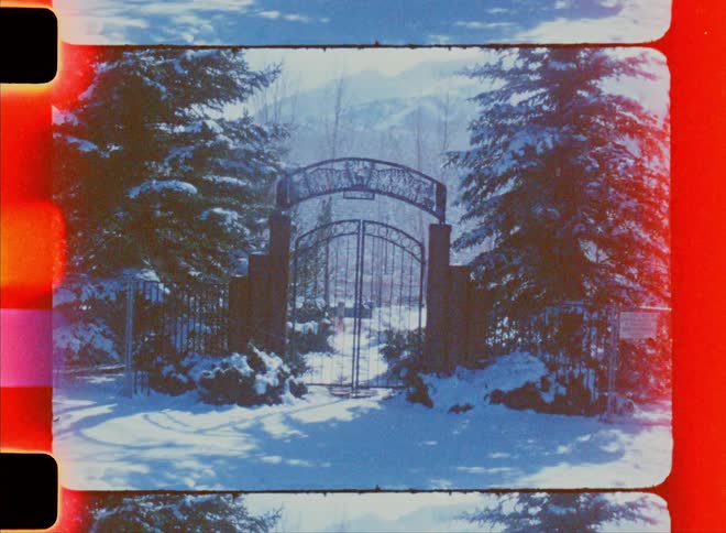 Facade of a gate with conifers around the mountain covered in snow