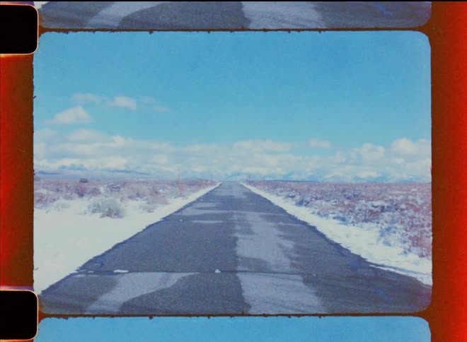 A desolate road surrounded by a desert landscape under a clear sky