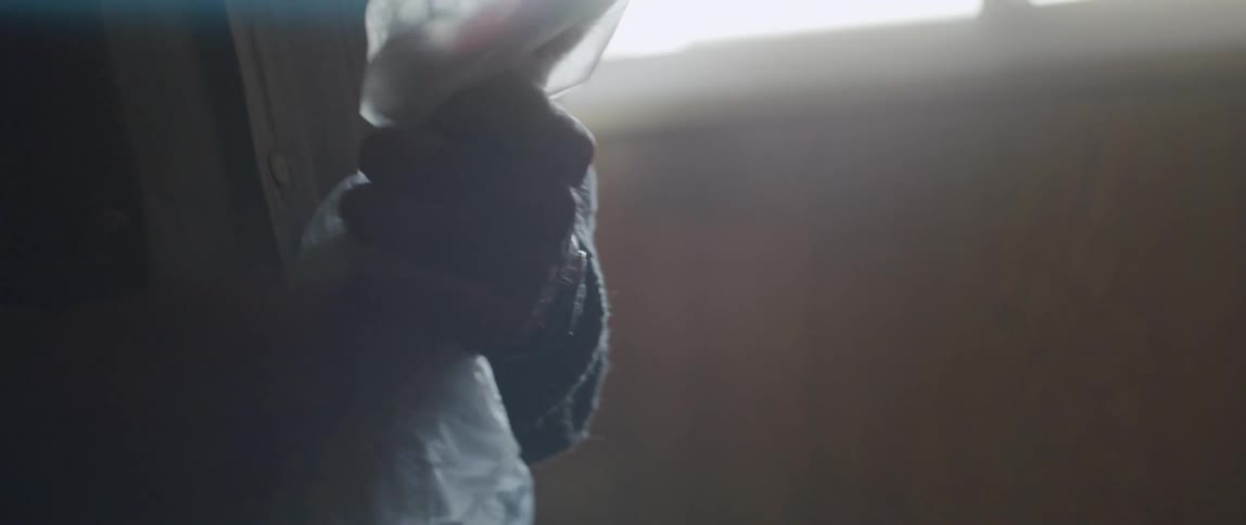 Elderly man stores an American flag in a plastic bag at home