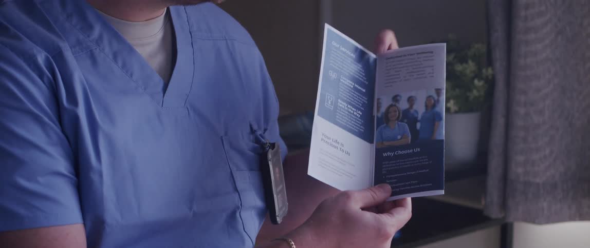 A male healthcare worker explains a medical pamphlet