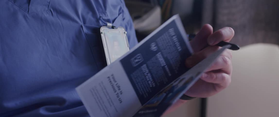 A hospital staff member presents a pamphlet