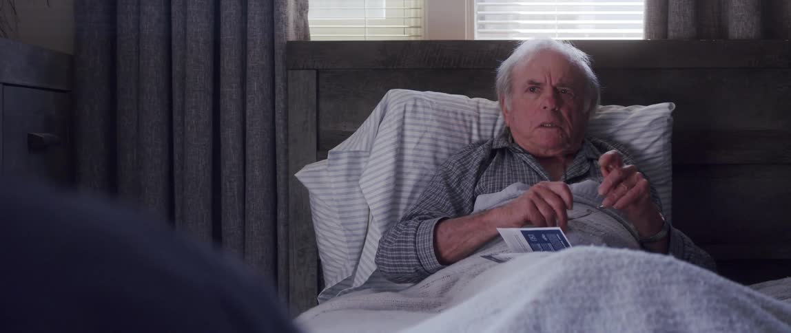 A doctor hands an elderly man a pamphlet