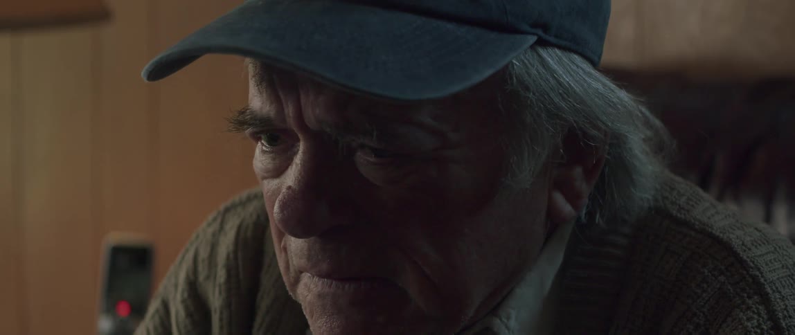 A face of an elderly man wearing a blue cap and he looks sad