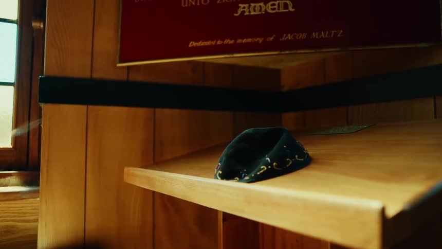 A crumpled yarmulke on a wooden stand