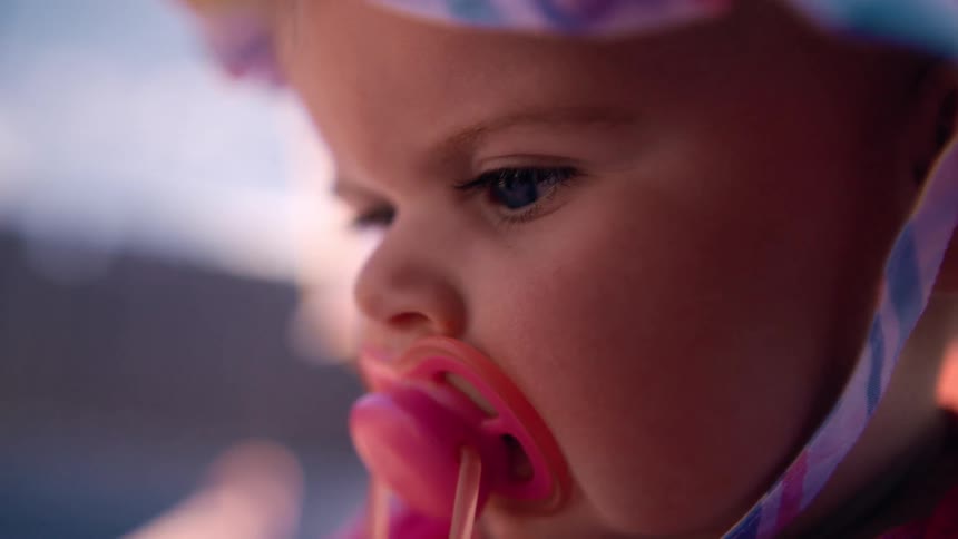 A baby with a bonnet and a pacifier