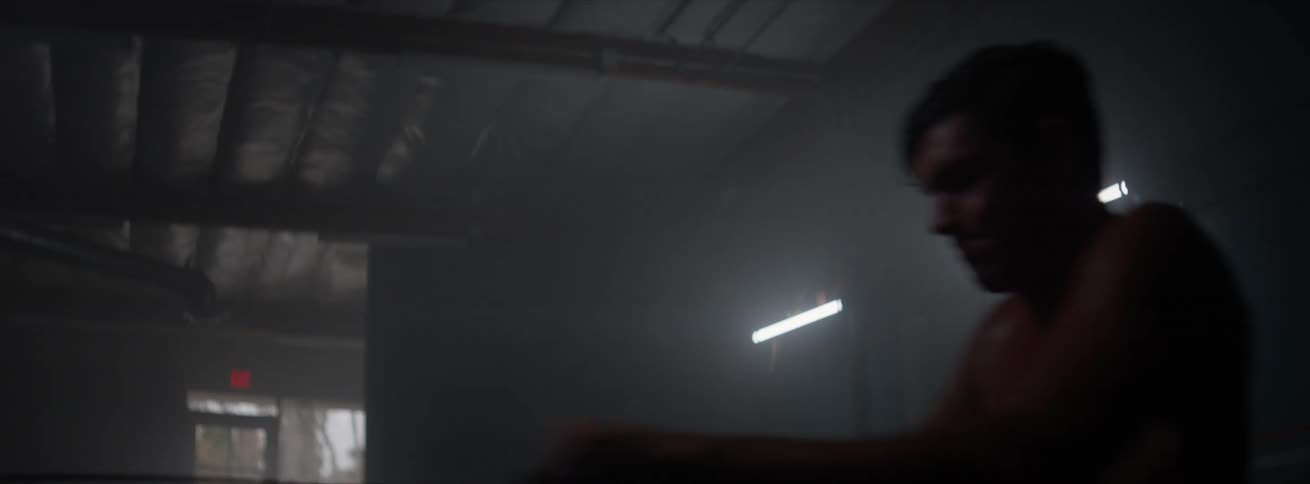 Close up of a man exercising on a dark gym