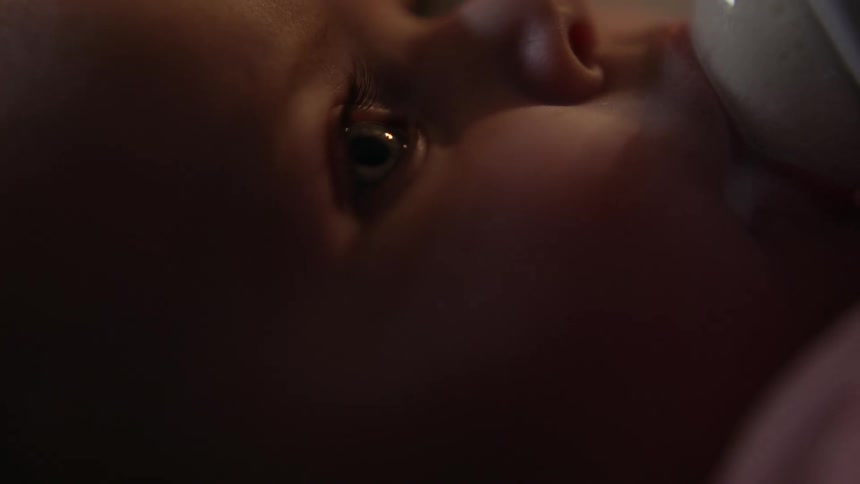 Side portrait of a baby breastfeeding from a bottle