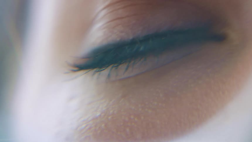 A blue eye with thick eyelashes blinks slowly then normally