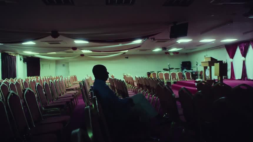 A man sits in an empty chapel