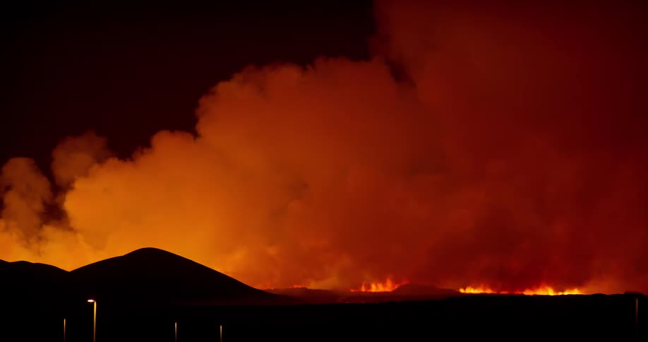 Fire occurring on a mountain in forests at night in slow motion