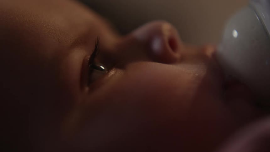 A baby is drinking from a bottle