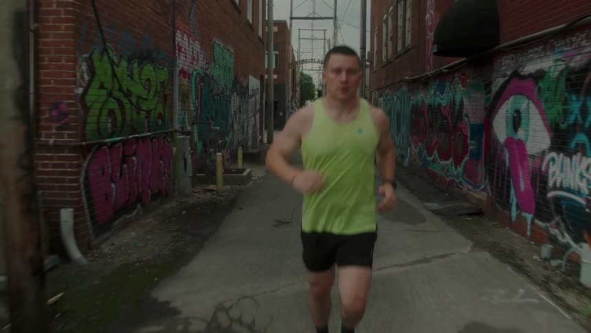 Man focused on determined running in straight direction in an alley