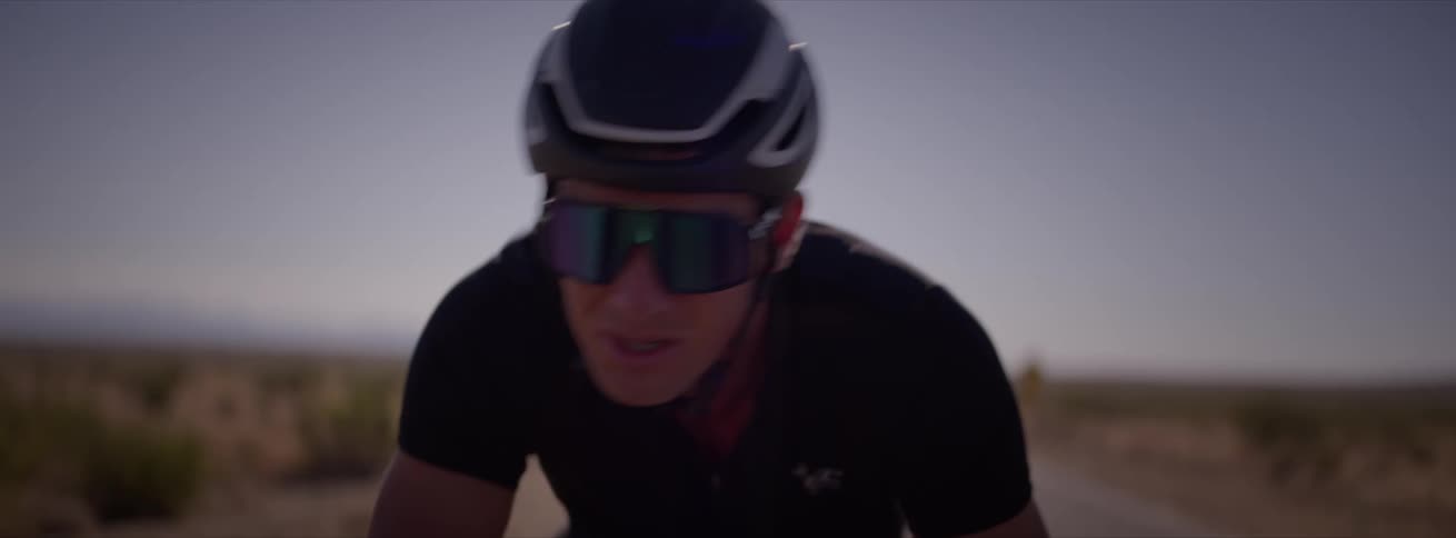 A man rides a bicycle on a desert road