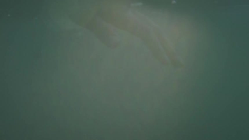 A person reaches in the murky water