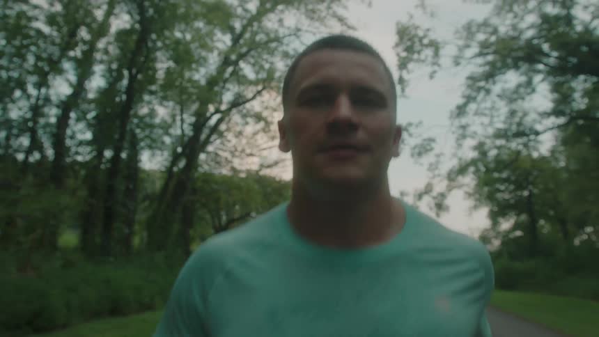 A man is running on a path through the woods