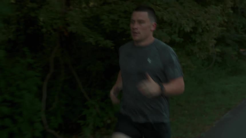 A man is running past the forest