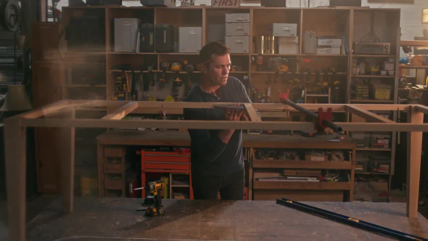 A carpenter assembling a wooden frame in the workshop