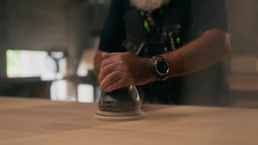 Man concentrated while polishing wood