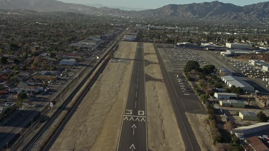 Approaching a runway in the city at the base of a mountain range